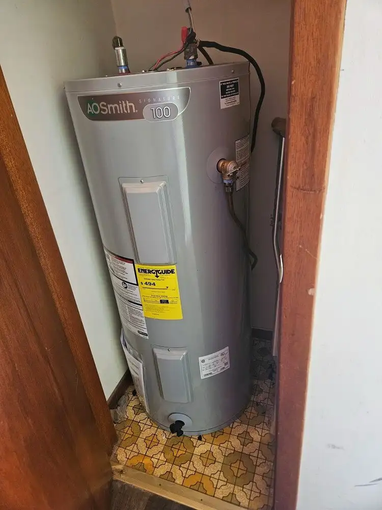 A tank water heater in a utility closet