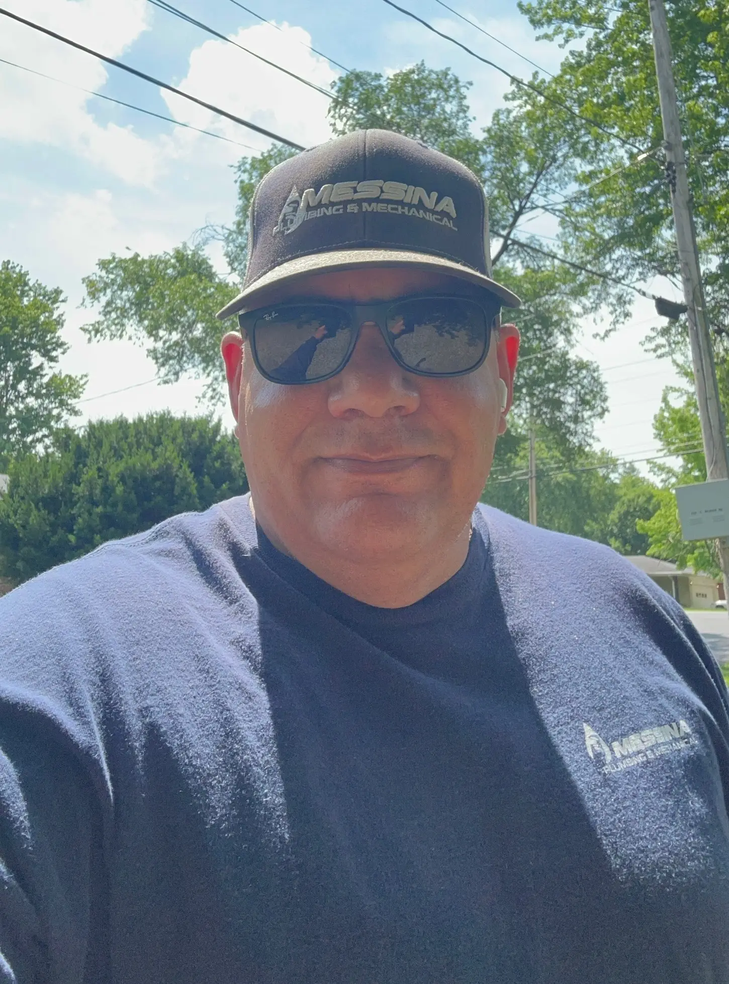 Joe Messina, master plumber and owner, in a Messina Plumbing and Mechanical cap and shirt